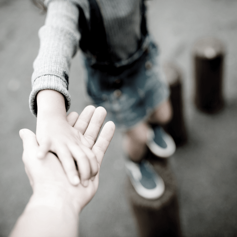 a child reaching out her parent's hand