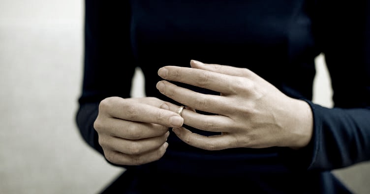 a woman removing her wedding ring